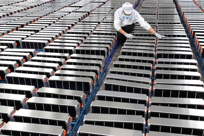 A factory worker stands near car batteries for Xinwangda Electric Vehicle Battery Company in Nanjing, China, on March 12, 2021.