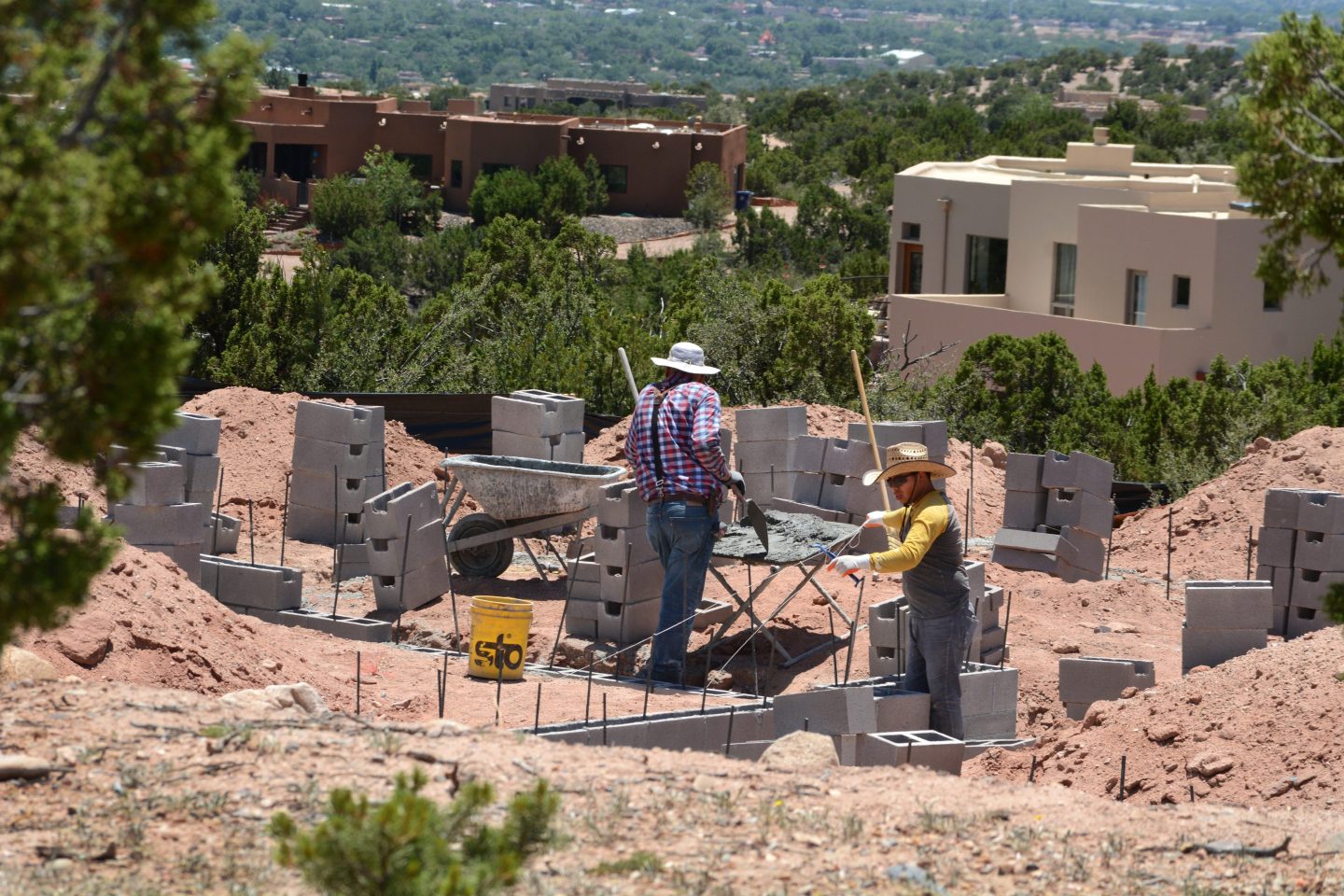 SANTA FE, NEW MEXICO &#8211; JULY 2, 2020:  Construction workers build a cinder block foundation for a new home being built overlooking Santa Fe, New Mexico. (Photo by Robert Alexander/Getty Images)