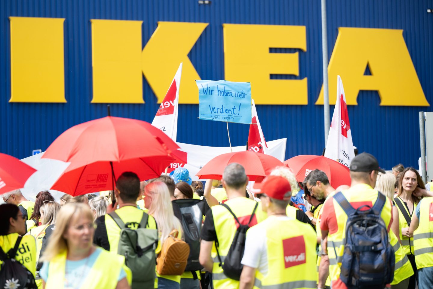 22 June 2023, Hesse, Hofheim/Wallau: Strikers stand in front of the Ikea headquarters and store during a warning strike with a sign reading &#8220;We deserve it&#8221; in front of the Ikea lettering. The service union Verdi is calling for a national warning strike day at 20 Ikea stores. Across Germany, the regional collective bargaining rounds for the retail sector have stalled. Photo: Sebastian Christoph Gollnow/dpa (Photo by Sebastian Gollnow/picture alliance via Getty Images)