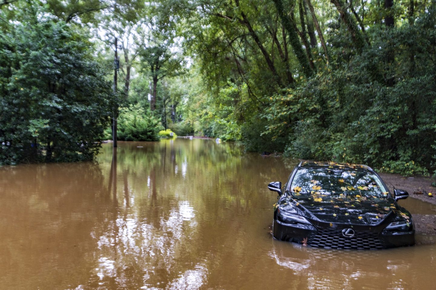 A partially submerged vehicle sits in flood water from after Hurricane Helene passed.