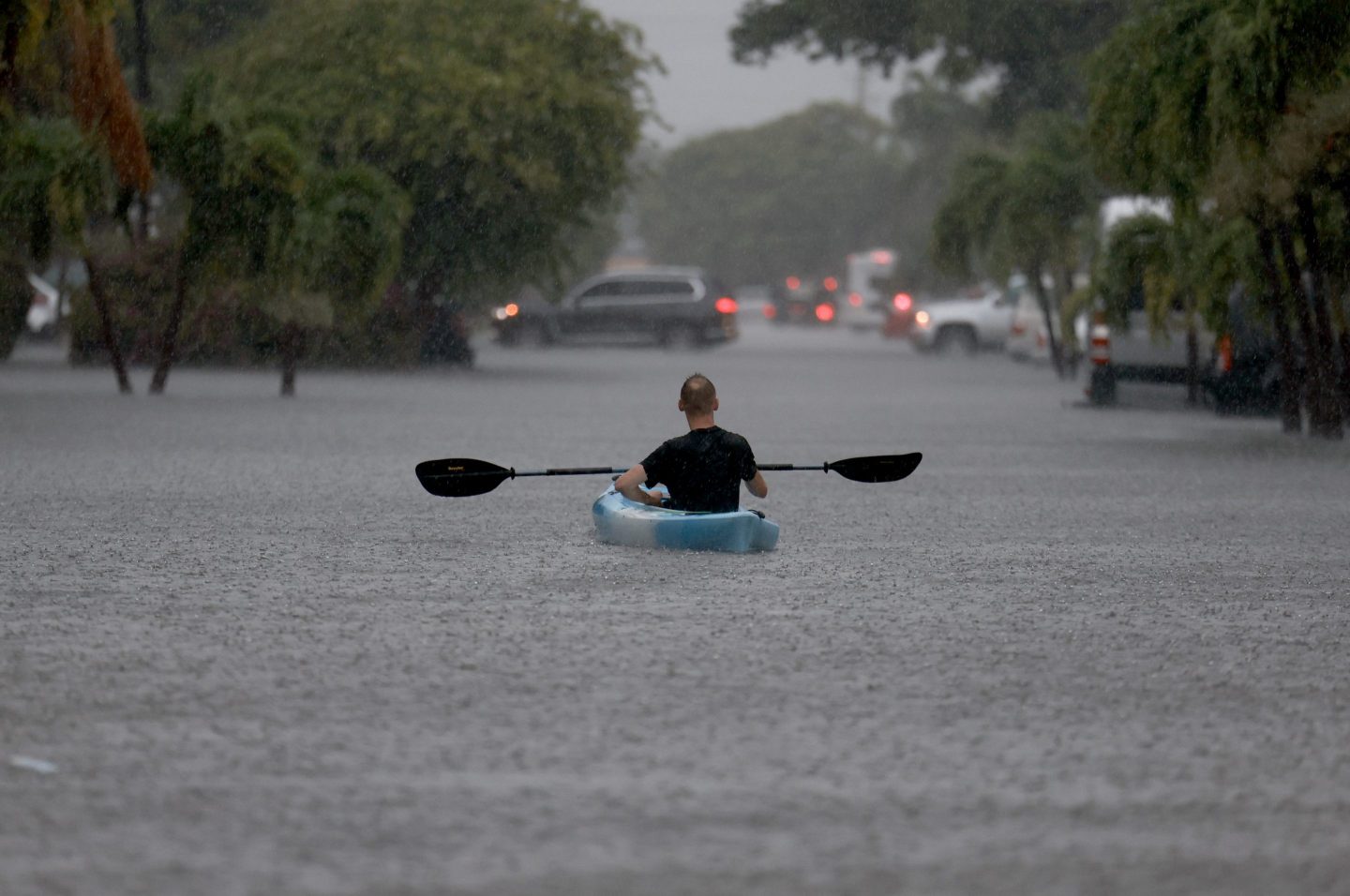 A person uses a kayak to float through a flooded street on Jun. 12 in Hollywood, Florida.