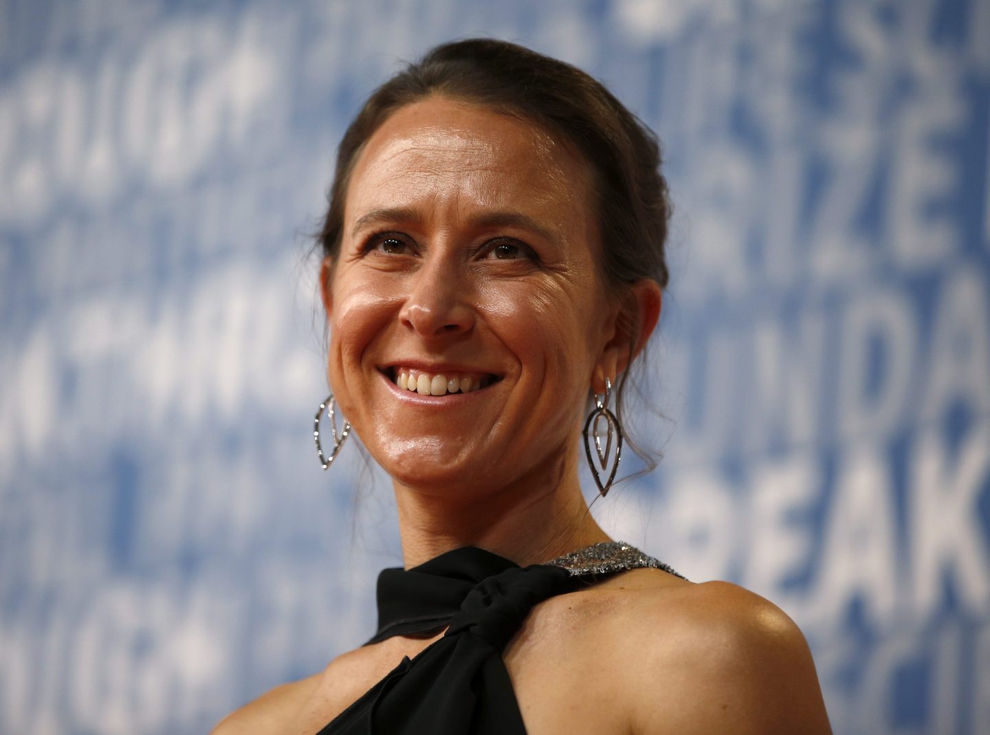 smiling businesswoman poses at a red carpet event