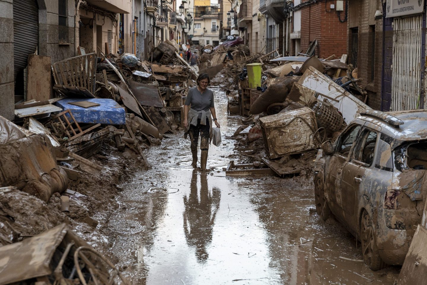 VALENCIA, SPAIN - NOVEMBER 02: A woman walks along a street full of mud and waste from houses after heavy rain and flooding hit large parts of the country on November 02, 2024 in Paiporta municipality, in Valencia, Spain. By Friday, Spanish authorities confirmed that at least 200 people had died, mostly in the Valencia region, amid the flooding that swept eastern and southern parts of the country starting on Tuesday. The intense rainfall event is known as a &quot;cold drop&quot; or DANA weather system. (Photo by Pablo Blazquez Dominguez/Getty Images)