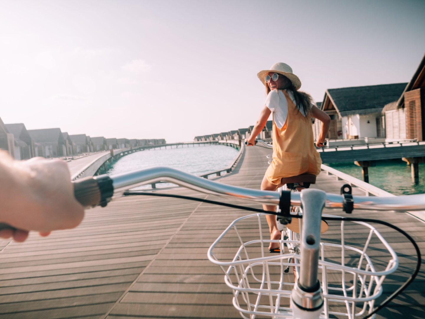 Pov point of view of couple cycling on tropical island. Personal perspective of person cycling with girlfriend in front. Tropical luxury vacations