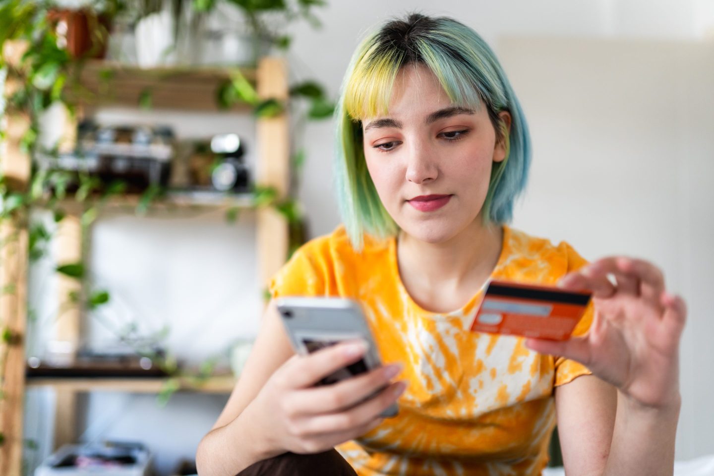 Young person purchasing something on their phone with their credit card