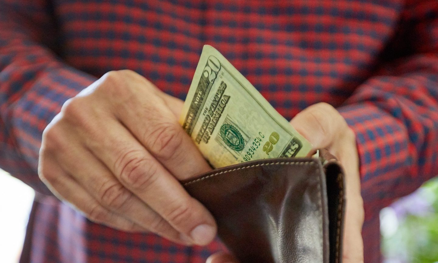 Close up on man's hand holding twenty dollar bill