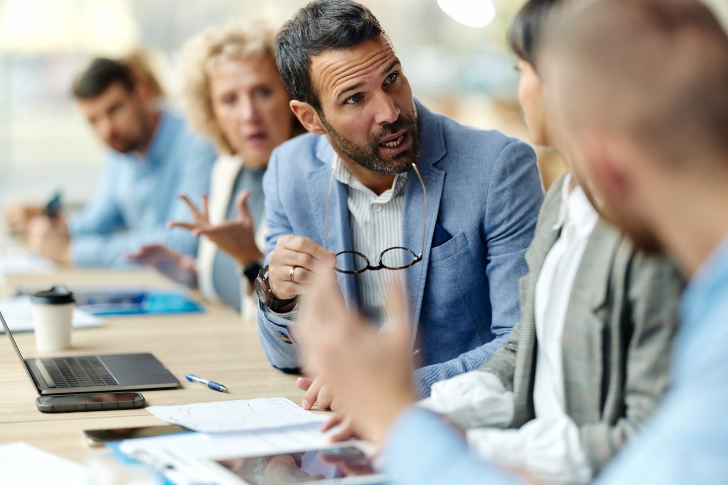 Displeased male entrepreneur talking about problems to his colleagues during a meeting in the office.