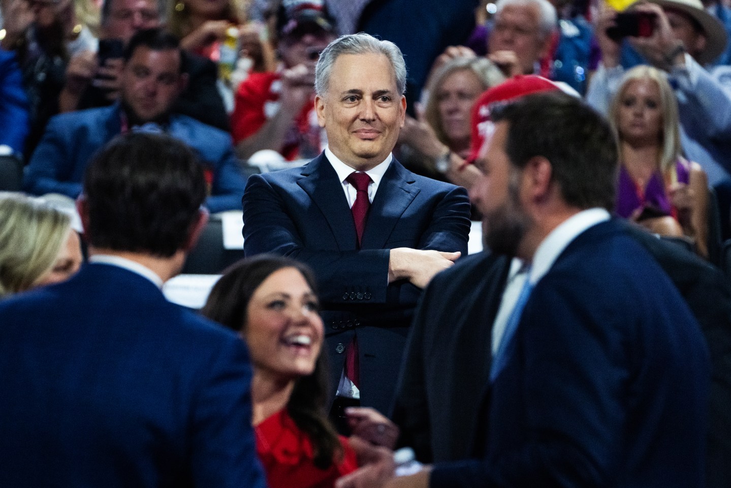 David Sacks standing with arms folded in a crowd at the Republican Nation Convention in 2024.