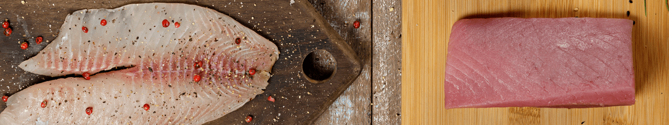 Foto de um filé de tilápia e de um lombo de atum dispostos em tábua de madeira