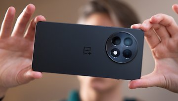 A person holding the back of a OnePlus 13R smartphone, showcasing its camera design.