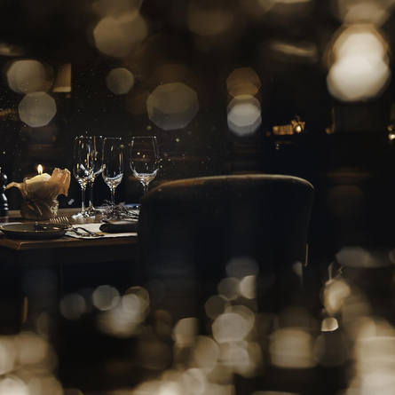 A table in a pub restaurant, with out of focus lights across the top and bottom of the picture.