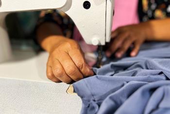 A cooperative member sews a garment at Olango Sindaw Ko Kauyagan Producer cooperative in Piagapo, village.