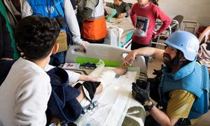 Une jeune patiente reçoit une visite lors d'une mission conjointe des Nations Unies dans un hôpital de Khan Younis, au Ghana.