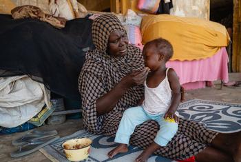 A woman feeds a child at a school used as a gathering point for displaced people in Port Sudan. (file)