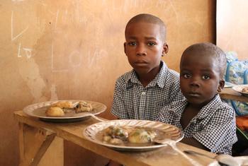 Wanafunzi wa shule ya msingi nchini Haiti wakijiandaa kupata mlo shuleni uliofanikishwa na Umoja wa Mataifa.