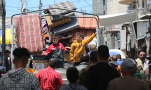 Two children stand at the back of a truck as their family flees Rafah in the south of the Gaza Strip.