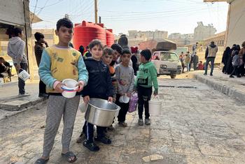 Children queue for hot food in Aleppo, Syria.