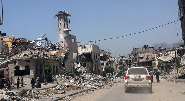 Un véhicule de l'ONU passe devant des bâtiments en ruines à Gaza City.