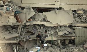 A man climbs up a destroyed building in Gaza.