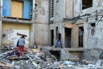 People survey the damage caused by a missile attack on a building in Kharkiv City, Ukraine.