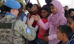 Un soldat de la paix salue les élèves de l'école Faouar en Syrie, l'une des quatre écoles rénovées par la Force des Nations unies pour le désengagement.