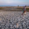 A man crosses parched farmland in East Nusa Tenggara Province, Indonesia