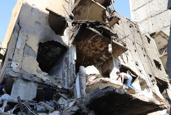 A man climbs over a destroyed building in the southern suburbs of Beirut, Lebanon.