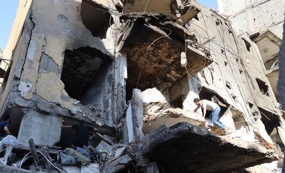 A man climbs over a destroyed building in the southern suburbs of Beirut, Lebanon.