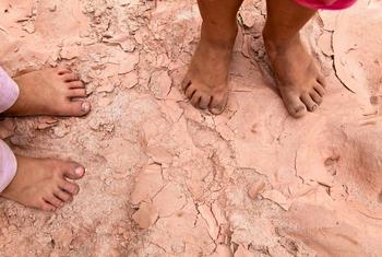 Two children stand barefoot on cracked, parched soil in a dry riverbed in southern Bolivia. (file)