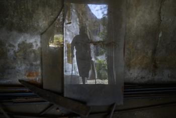 The silhouette of a 15-year-old child on crutches. He lost his left leg after accidentally stepping on a landmine in a rice field.