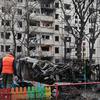 A resident stands in front of his apartment building in Kyiv which was in an overnight strike in December 2023.