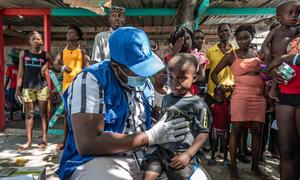 Des Haïtiens déplacés et sans-abri se rassemblent pour recevoir des soins médicaux gratuits dans une clinique mobile de l'OIM sur la place Clercine à Tabarre, Port-au-Prince.