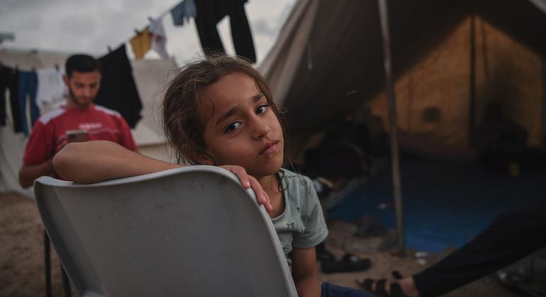 A girl sits in front of her tent at an UNRWA shelter camp in Khan Younis, southern Gaza Strip.