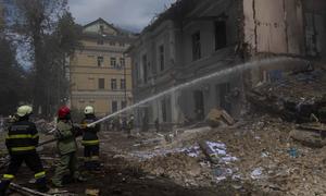 Firefighters extinguish a fire in a building struck by a missile in Kyiv, Ukraine.