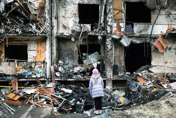 On 25 February 2022 in Kyiv, Ukraine, a girl looks at a crater left by an explosion in front of an apartment building which was heavily damaged during ongoing military operations.