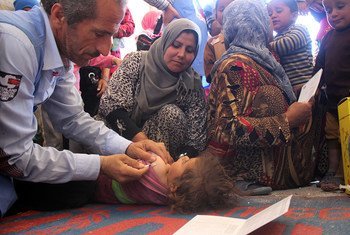 Health workers vaccinate a child in a medical centre in Al-Radwanieh village, rural Aleppo.