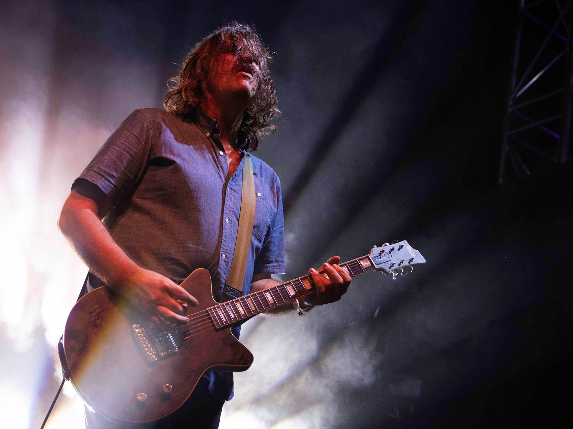 Kurt Ballou on stage in 2023, standing before bright white lights with guitar in hand