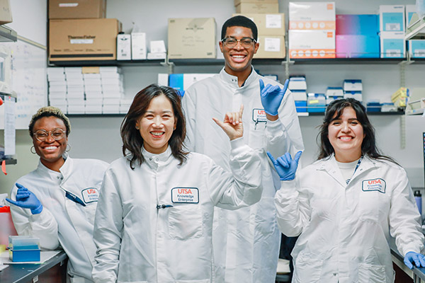 Four students in lab outfits