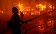 Firefighters battle the Eaton Fire in strong winds as many homes burn on January 7, 2025 in Pasadena, California.