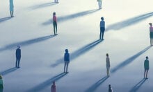 A group of people standing at a distance from each other.