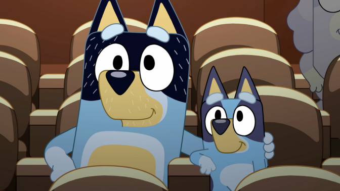 Bluey and her dad Bandit watching a movie in a movie theatre in 'Bluey' Season 2 episode 'Movies.'