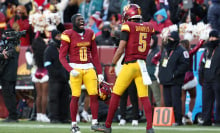 Jayden Daniels #5 of the Washington Commanders is congratulated by Mike Sainristil #0 after throwing a touchdown pass against the Philadelphia Eagles during the fourth quarter at Northwest Stadium on December 22, 2024 in Landover, Maryland.