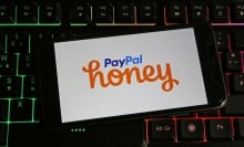 Closeup of smartphone on pc keyboard with logo lettering of Paypal Honey