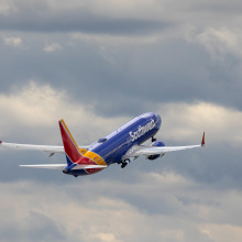 Southwest airplane flying in sky with clouds