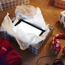 Wrapped and unwrapped presents on the floor, including a tablet and headphones.