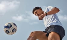 Person playing soccer and wearing Fitbit Charge 3