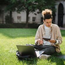 Man on grass with laptop