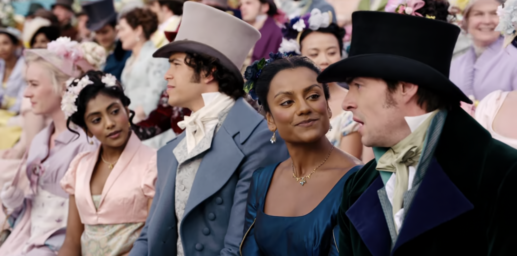 Two young men and two young women in Regency clothing watching horse races. 