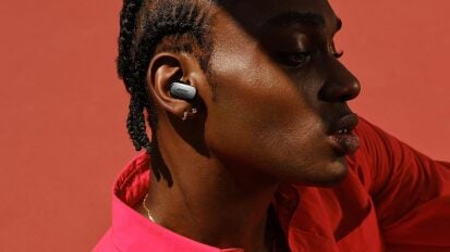 Black person wearing bose quietcomfort ultra earbuds in ear