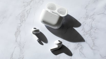 The 3rd gen Apple AirPods laying on a marbled surface next to their case